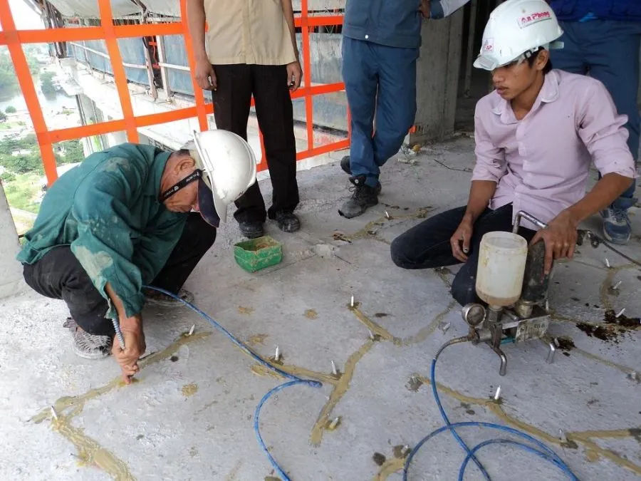 Bơm keo Sikadur 752 vào vết nứt mái bê tông bằng máy bơm áp lực, đảm bảo thẩm thấu sâu