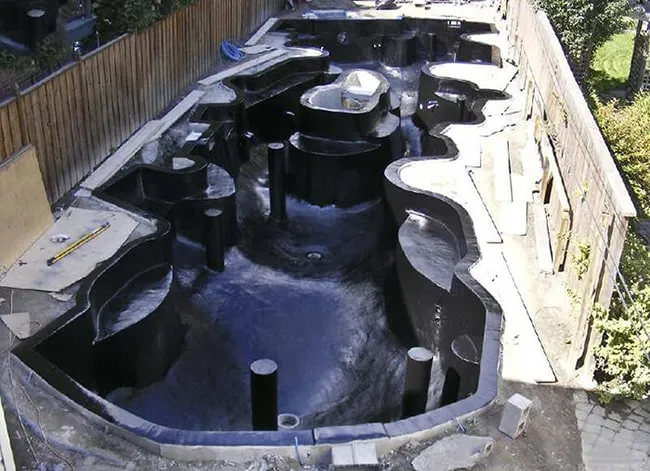 Cấu trúc phần thô của hồ cá koi đang được xây dựng, chuẩn bị cho hệ thống lọc.
