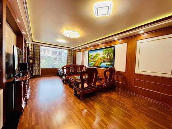 Chi tiết tường phòng khách ốp tấm nhựa vân gỗ và tranh nghệ thuật