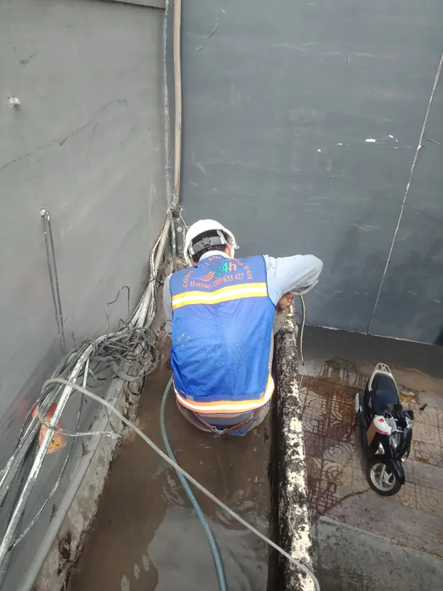 Công nhân đang thi công quét lớp chống thấm Sikaproof Membrane lên bề mặt sê nô