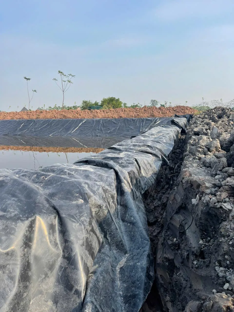 Công nhân đang trải bạt HDPE trên kênh