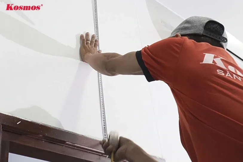 Đo đạc chính xác diện tích tường bằng thước dây trước khi ốp tấm nhựa giả đá, đảm bảo cắt tấm vừa vặn và tiết kiệm vật liệu.