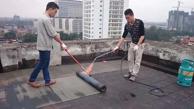 Đội ngũ kỹ thuật viên đang thi công màng chống thấm khò nóng chuyên nghiệp