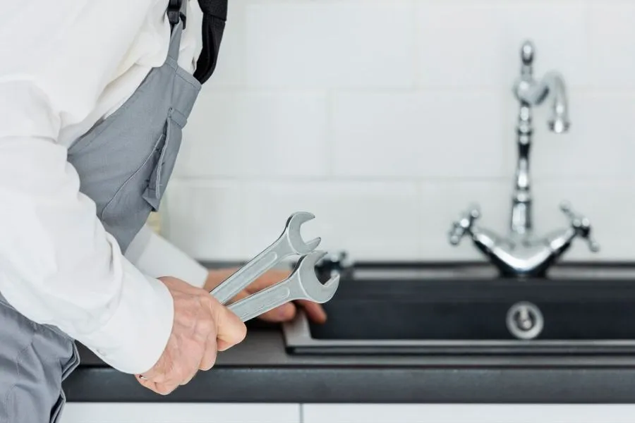 Hình ảnh chuyên gia kiểm tra định kỳ tình trạng keo dán chống thấm bồn rửa chén để đảm bảo độ bền
