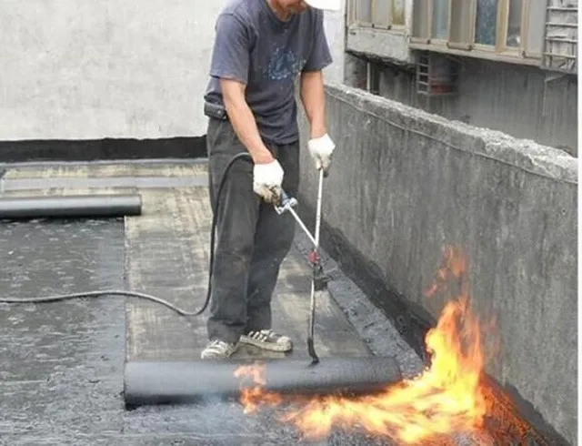 Hình ảnh sử dụng đèn khò gas để thi công màng bitum chống thấm