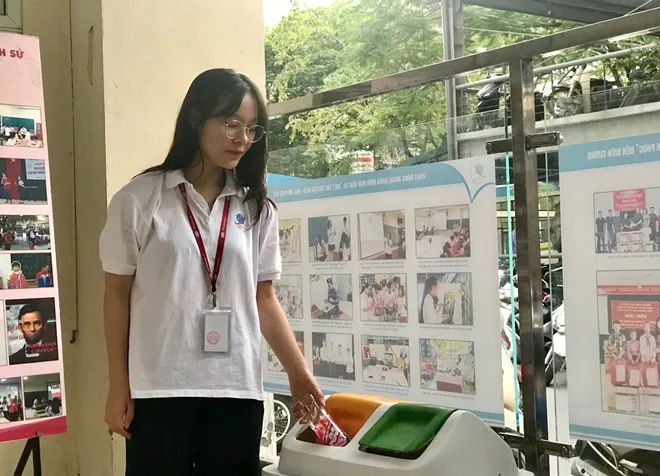 Học sinh vứt rác vào thùng phân loại ở trường học