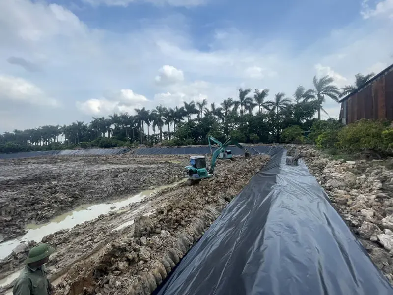Kỹ thuật viên đang sử dụng máy hàn nhựa chuyên dụng để hàn các tấm màng chống thấm HDPE trong quy trình thi công bạt lót ao hồ