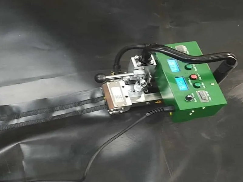 Máy hàn nhiệt tự động đang dán nối bạt HDPE, tạo ra mối hàn chắc chắn, chống thấm hiệu quả