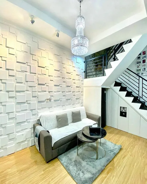 Người thợ đang bôi keo cẩn thận lên mặt sau của tấm nhựa 3D dán tường trước khi lắp đặt