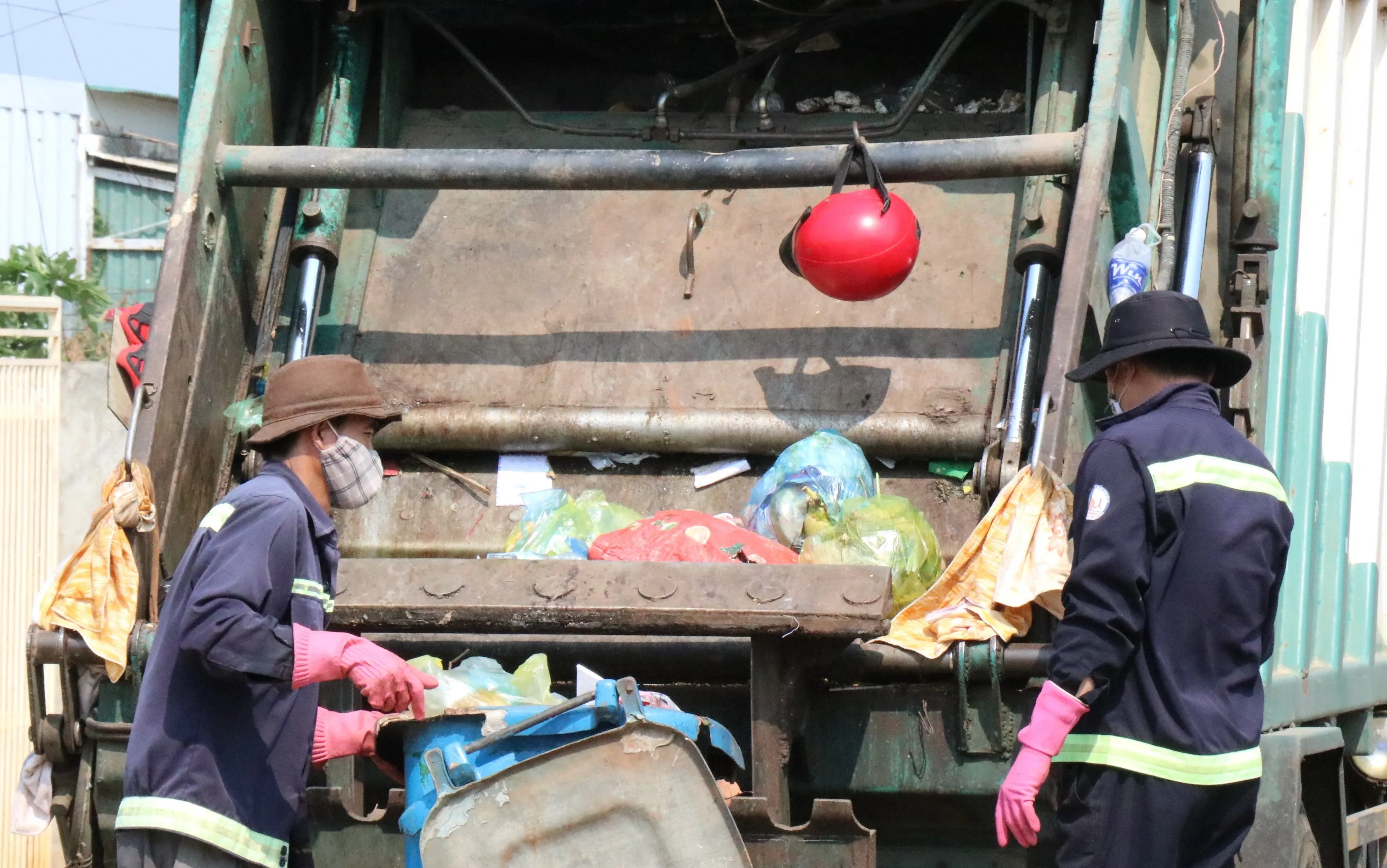 Nhân viên vệ sinh môi trường thu gom rác thải trong trang phục bảo hộ