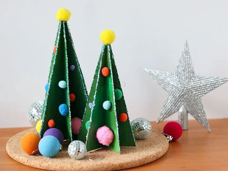 Những cây thông Noel mini trang trí được làm thủ công từ giấy carton tái chế, mang lại không khí lễ hội ấm áp và ý nghĩa bền vững.