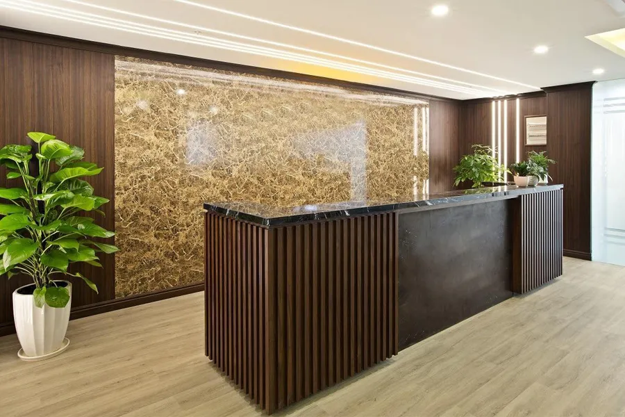 Thiết kế quầy lễ tân sang trọng với tấm alu vân đá màu hổ phách kết hợp tủ gỗ