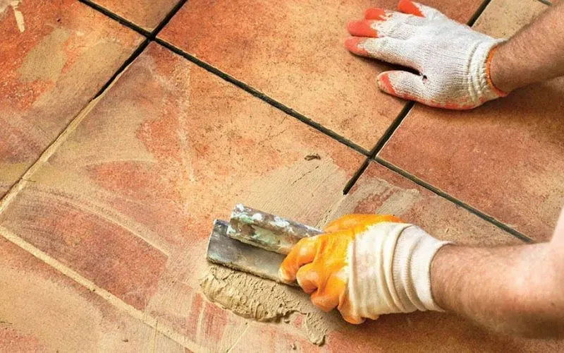 Thợ thi công dùng keo chà ron chuyên dụng để chống thấm và gia cố mạch gạch