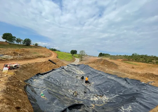 Trải màng HDPE với bao cát giữ định vị